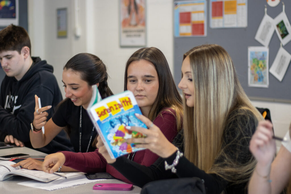 Students looking at a Welsh textbook in class