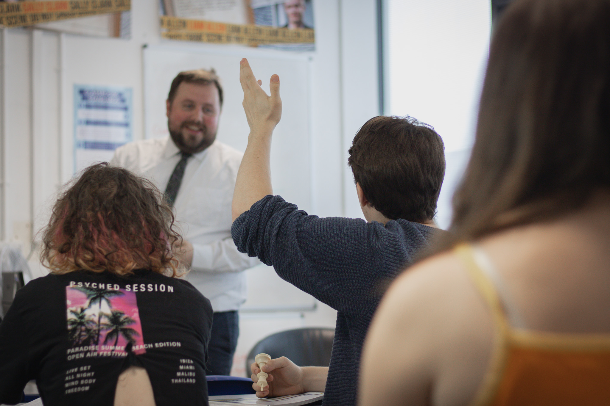 Image of student raising their hand for Mr Ragget in Criminology, accompanying text on Pastoral Support in St David's Catholic Sixth Form College