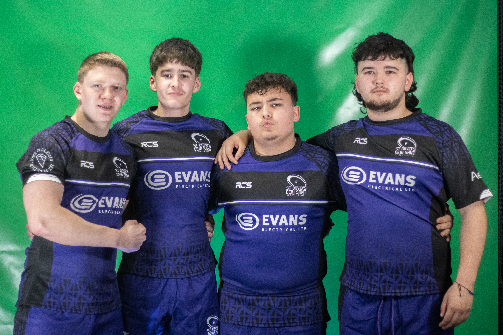 A group of St David's Rugby Academy players in front of a green screen.