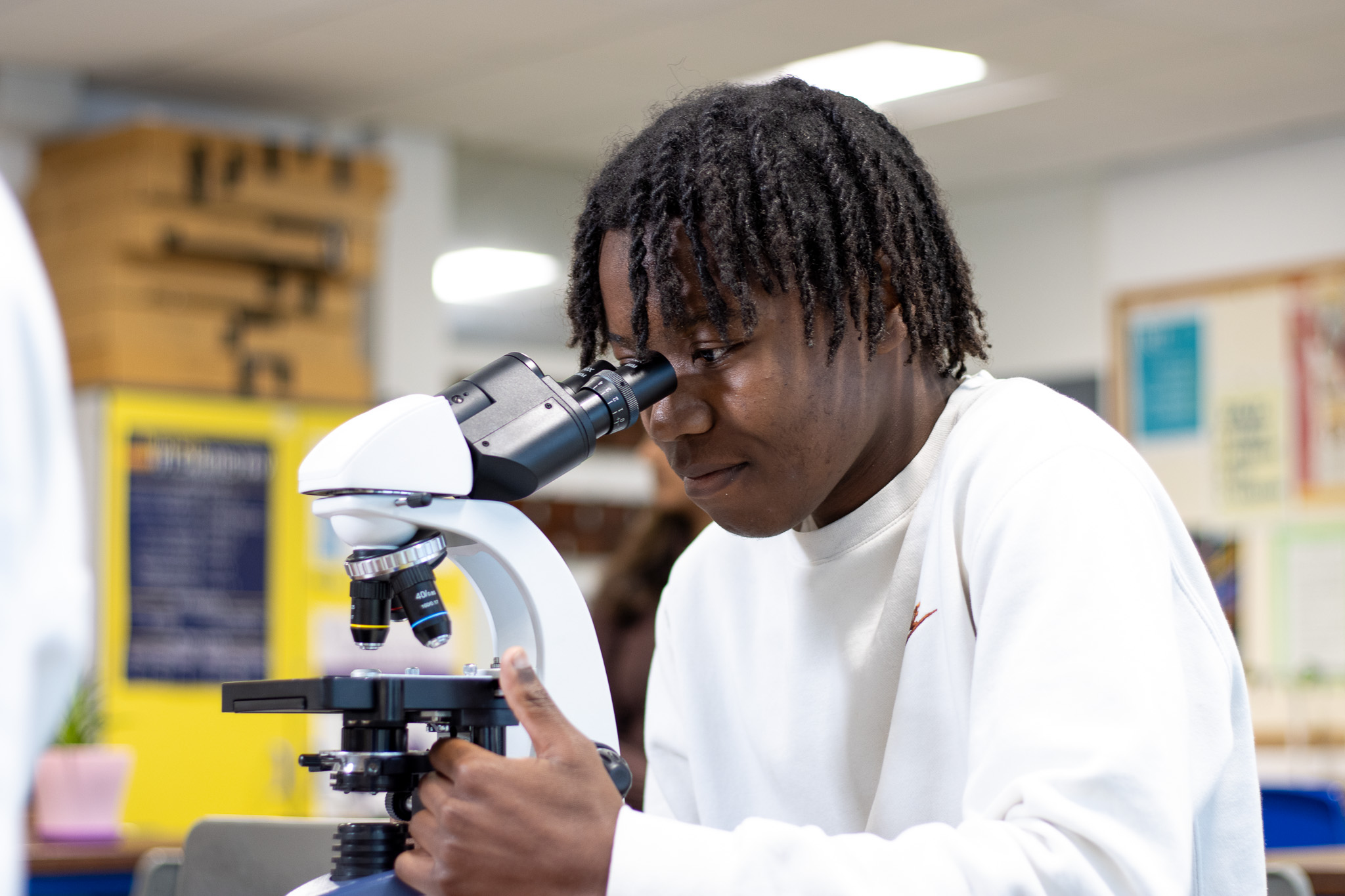 An image of an Honours Programme science student looking through a telescope