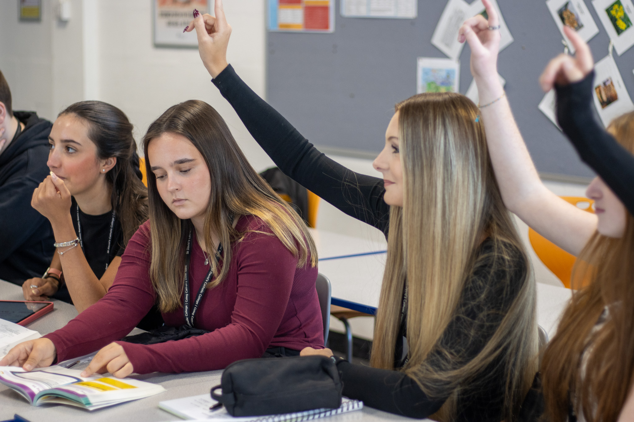 Students with their hands up in a Welsh lesson