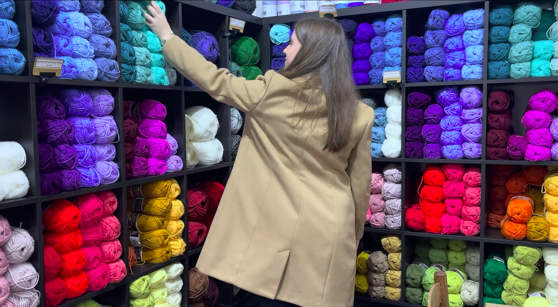 Former St David's College student reaching for colourful wool with her back turned